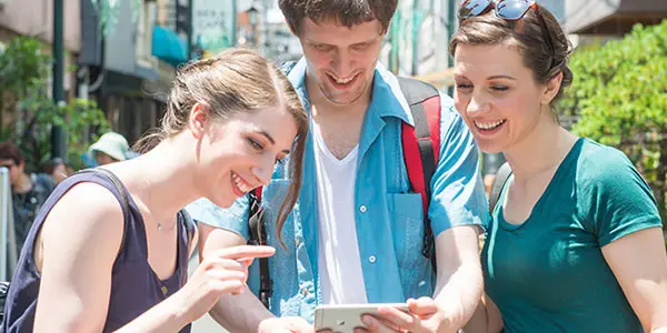 観光客がスマートフォンで地域情報を確認している様子