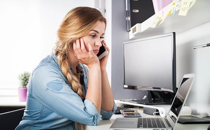 ノートパソコンを見ながら考え込む女性。AIに指示した結果が期待とずれていて、戸惑っている様子